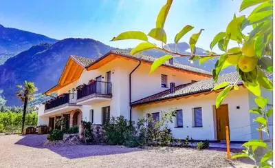 a white house with mountains in the background at Gisshübelhof in Andrian