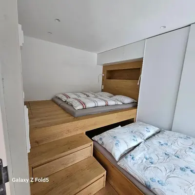 two beds are in a room with wooden floors at Sonnenparadies in San Genesio Atesino