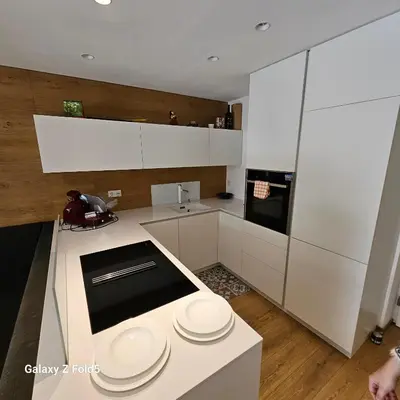 a kitchen with white cabinets and white plates on a counter at Sonnenparadies in San Genesio Atesino