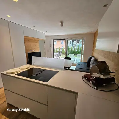 a kitchen with a counter top and a living room at Sonnenparadies in San Genesio Atesino