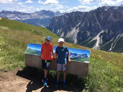 two boys standing next to a sign on a mountain at Residence Laitacherhof - Modern Apartments with Sauna in Chiusa