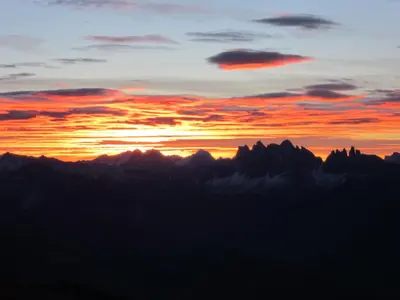 a sunset over a mountain range with clouds at Residence Laitacherhof - Modern Apartments with Sauna in Chiusa