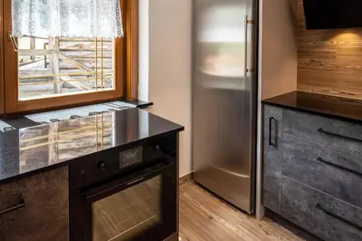 a kitchen with a stainless steel refrigerator and a window at Chalet Funtanacia in La Villa