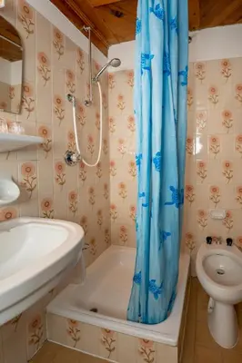 a bathroom with a tub and a sink and a toilet at Chalet Funtanacia in La Villa