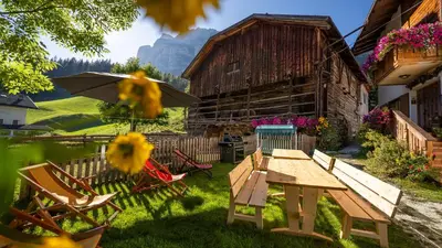 a picnic table and chairs in a yard with a barn at Chalet Funtanacia in La Villa
