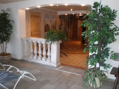 a hallway with potted plants and a staircase at Hotel Thuinerwaldele in Vipiteno