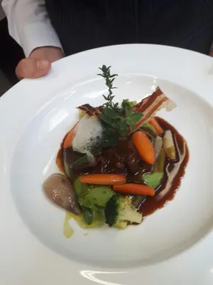 a white plate of food with vegetables on it at Hotel Thuinerwaldele in Vipiteno