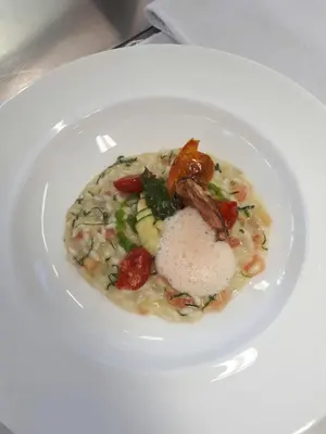 a white bowl of food on a white plate at Hotel Thuinerwaldele in Vipiteno
