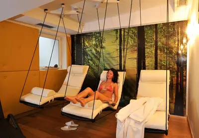a woman sitting on a swing in a room at Hotel Pareda in Canazei
