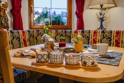 a table with food and drinks on a couch at Garni Hotel Belalp in Santa Cristina in Val Gardena