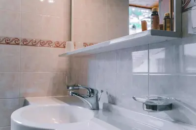 a bathroom with a sink and a mirror at Garni Hotel Belalp in Santa Cristina in Val Gardena