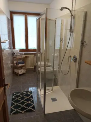 a bathroom with a shower with a toilet and a sink at Appartamento Cologna in Castelfondo
