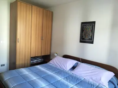a bedroom with a blue bed and a wooden cabinet at Appartamento Cologna in Castelfondo