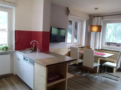 a kitchen with a sink and a table and a tv at Prà de Metz Apartments in Santa Cristina in Val Gardena