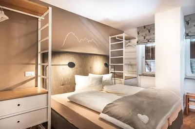 a small bedroom with a bed with a shelf at Prà de Metz Apartments in Santa Cristina in Val Gardena