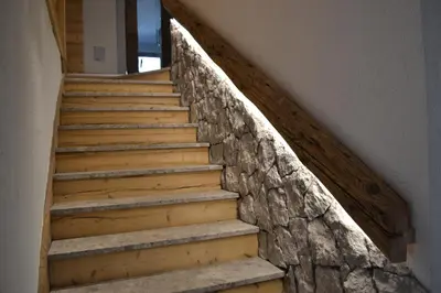 a staircase in a house with a stone wall at B&B Sot l'Agner - Ospitalità Diffusa Conca Agordina in Taibon