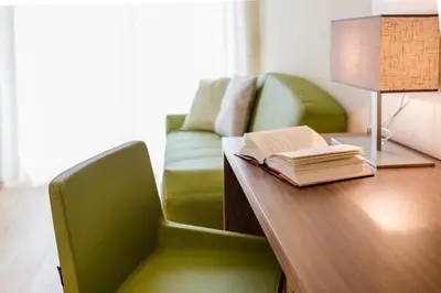 a room with a desk with a chair and a book at Hotel Residence Pernhof in Termeno