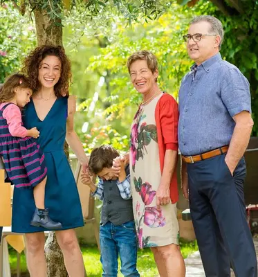 a family posing for a picture in a park at Hotel Residence Pernhof in Termeno