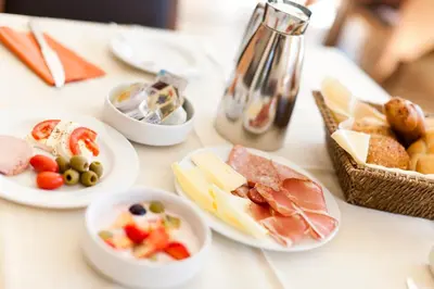 a white table with plates of food on it at Hotel Residence Pernhof in Termeno