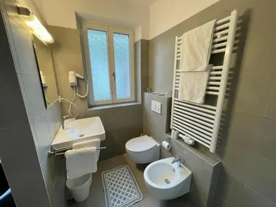 a bathroom with a white toilet and a sink at Transit Rooms - Your Stopover, Free Parking in Vipiteno