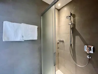 a bathroom with a shower with a glass door at Transit Rooms - Your Stopover, Free Parking in Vipiteno