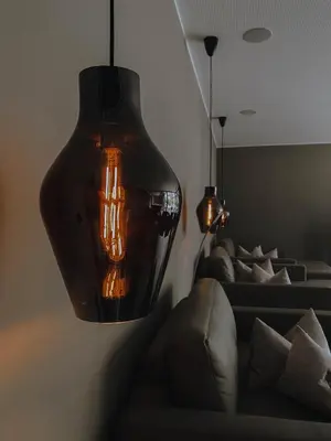 a living room with a couch and a hanging light at Klein Fein Hotel Anderlahn in Parcines