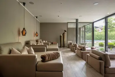 a waiting room with couches and windows at Klein Fein Hotel Anderlahn in Parcines