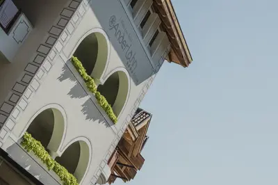 a building with a balcony with plants on it at Klein Fein Hotel Anderlahn in Parcines