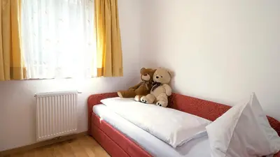 two teddy bears sitting on the back of a bed at Hotel Sonnenhof in Marlengo