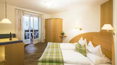 a hotel room with a bed and a balcony at Hotel Sonnenhof in Marlengo