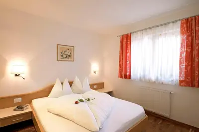 a hotel room with a bed and a window at Hotel Sonnenhof in Marlengo