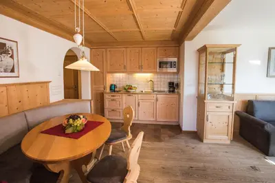 a kitchen and living room with a table and a couch at Apartments Pitschlmann in Fiè