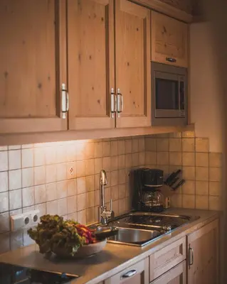 a kitchen with a sink and a bowl of vegetables on the counter at Apartments Pitschlmann in Fiè