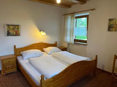 a bedroom with a bed with white sheets and a window at Haus Santner in Fiè