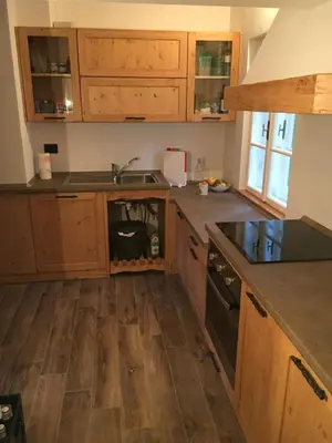 a kitchen with wooden cabinets and a sink at il Finferlo in Bellamonte
