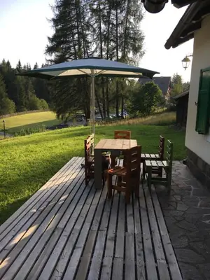 a table and chairs with an umbrella on a deck at il Finferlo in Bellamonte