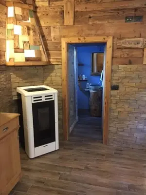 a kitchen with a stove and a door to a bathroom at il Finferlo in Bellamonte