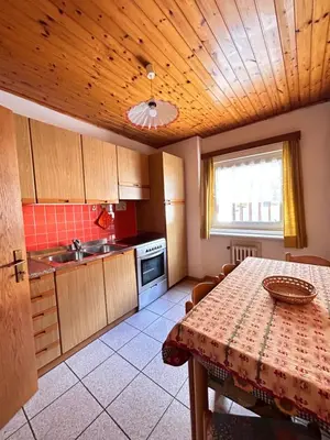 a kitchen with a table and a sink and a counter at Apartment Nido in Selva di Val Gardena