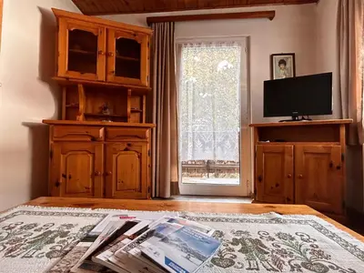 a living room with a television and a table with newspapers at Apartment Nido in Selva di Val Gardena