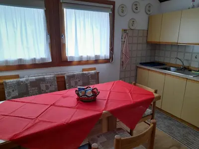 a kitchen with a table with a red table cloth on it at Piccolo Igloo in Falcade