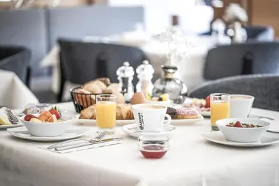 a table with breakfast foods and drinks on it at Hotel Wieser in Campo di Trens