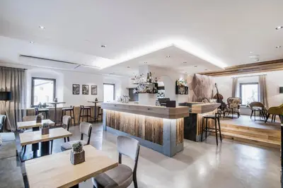 a restaurant with a bar and some tables and chairs at Hotel Wieser in Campo di Trens