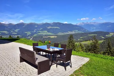 a table and chairs with a view of mountains at Pirchnerhof in San Lorenzo di Sebato