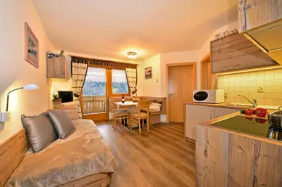 a room with a kitchen and a living room at Pirchnerhof in San Lorenzo di Sebato