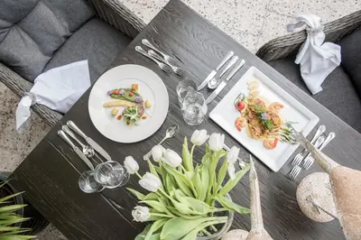 a table with two plates of food and flowers on it at Hotel Walter in Schenna