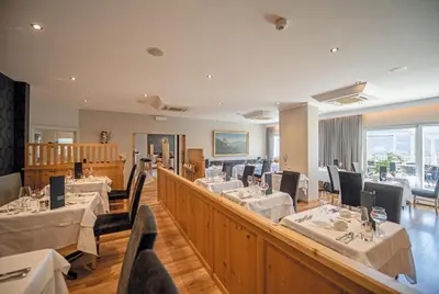 a restaurant with tables and chairs in a room at Hotel Walter in Schenna
