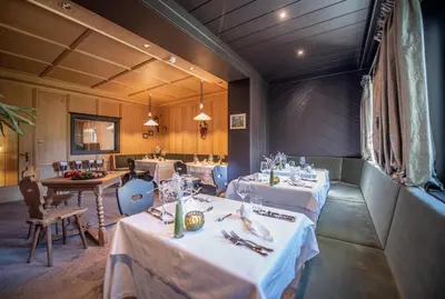 a dining room with tables and chairs with white tablecloths at Hotel Walter in Schenna