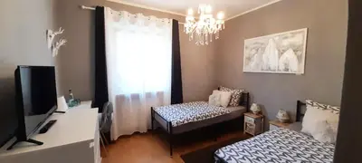 a living room with two beds and a television at HomeSuiteHome in Merano