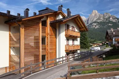 a house with wooden balconies and a mountain at Casa Chris by AMA Val di Fassa in Pozza di Fassa