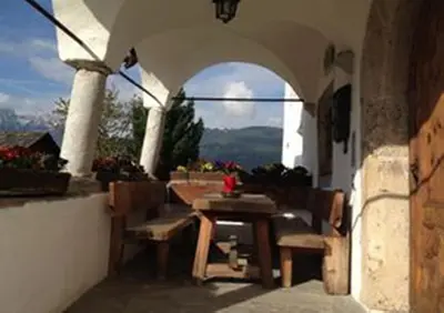 an outdoor patio with a table and chairs and a window at Ansitz Goller in Rasun di Sopra